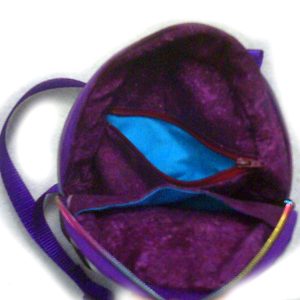 The bag's interior, showing the purple lining, and two interior pockets, one of which has a zipper closure. The whole bag also has a zip closure for double security.