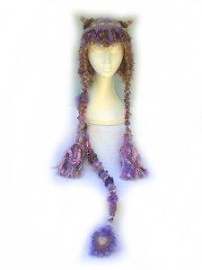 Mushroom Magic Imp Hat, a crochet ear flap hat with tiny horns and a long pointed tail.